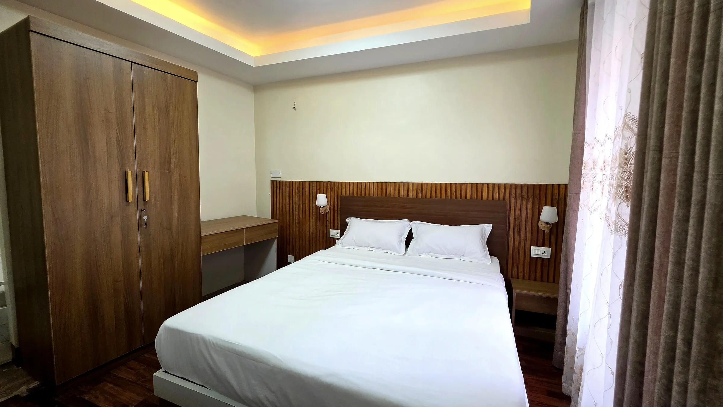 Double bedroom with wardrobe and curtained window