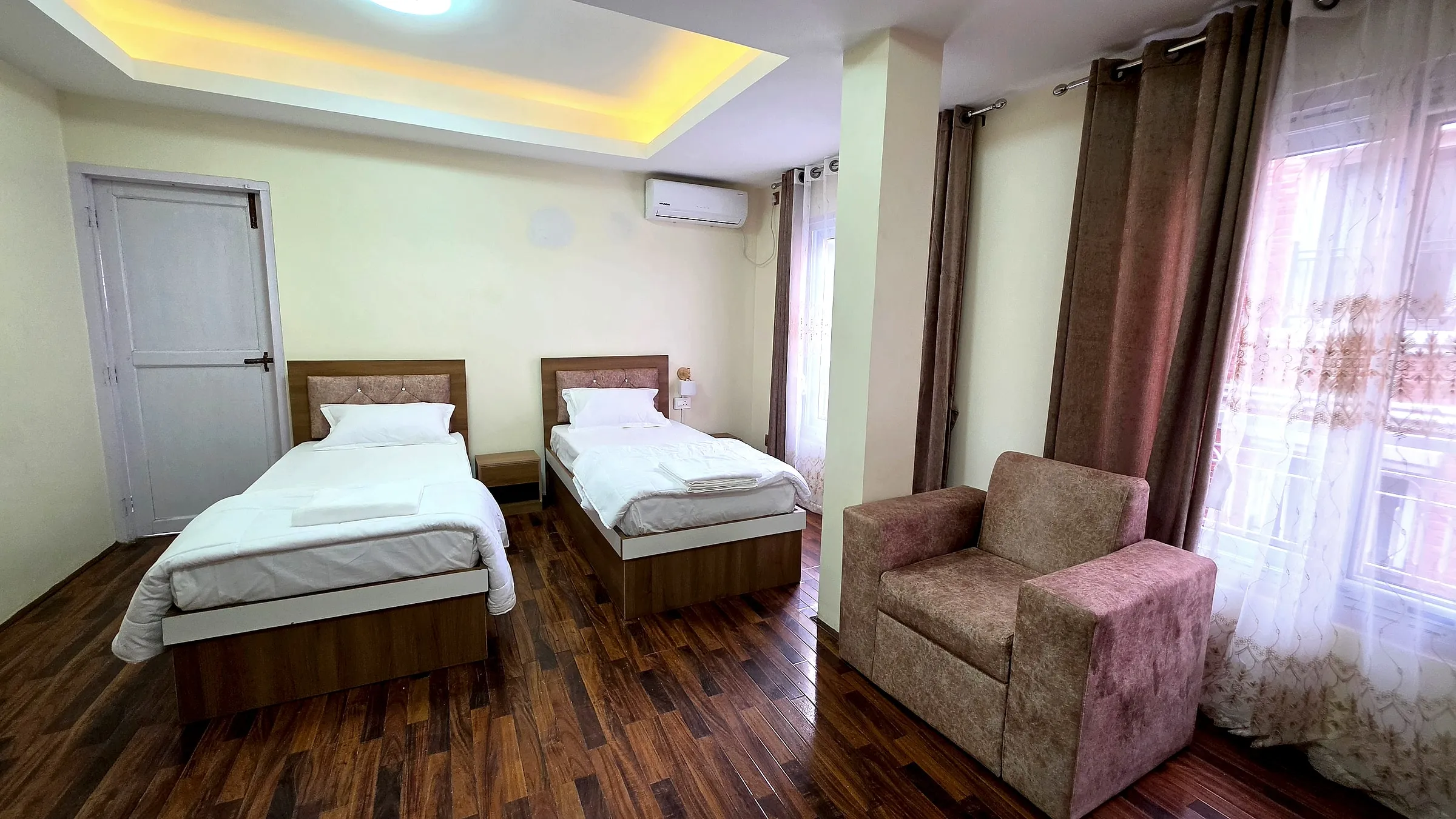 Twin-bed room with armchair and natural light